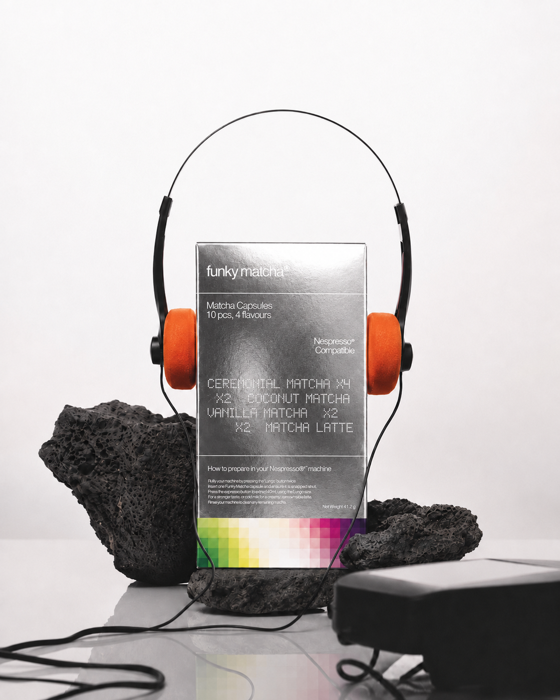 Funky Matcha Signature Selection box styled with orange headphones and black volcanic rocks
