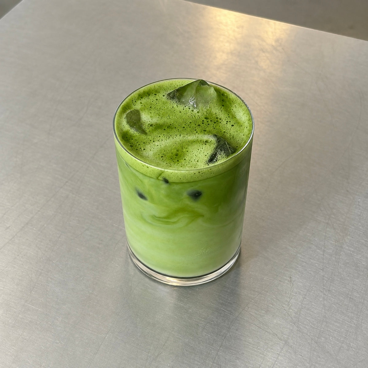 Iced Funky Matcha Chiran, Kagoshima matcha latte in a glass on a steel surface
